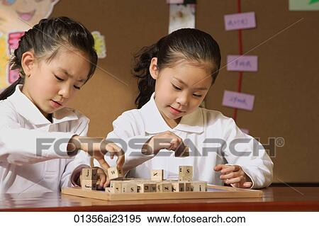 Stock Photography - Schoolgirls in class playing with blocks. Fotosearch