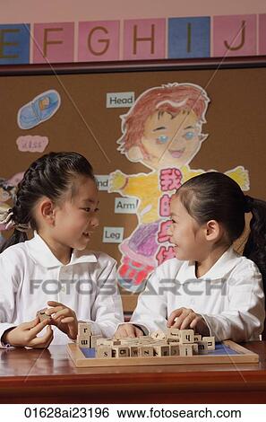 Schoolgirls in class playing with blocks looking at each other View Large Photo Image Stock Photograph - Schoolgirls in class playing with blocks looking at each other. Fotosearch