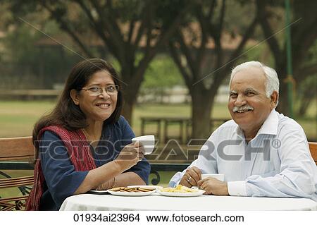 Picture - senior couple having coffee outdoors. Fotosearch