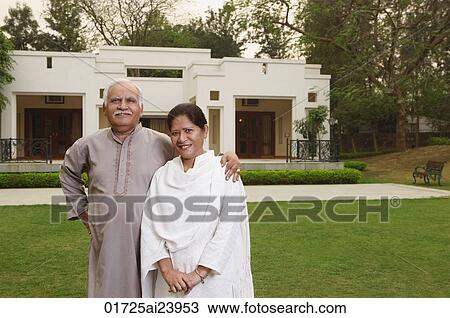 Stock Image - senior couple in front of home. Fotosearch