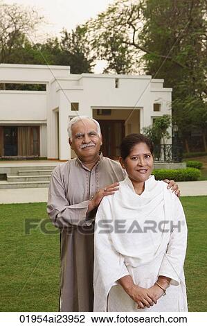 Stock Image - senior couple in front of home. Fotosearch