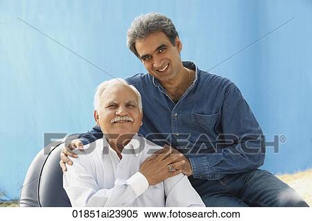 Senior man in chair, adult son behind, clasped hands View Large Photo Image Stock Photography - Senior man in chair, adult son behind, clasped hands. Fotosearch