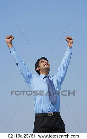 Stock Image - smiling businessman with both fists in the air. Fotosearch