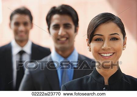 smiling businesswoman, two businessman in background View Large Photo Image Stock Image - smiling businesswoman, two businessman in background. Fotosearch