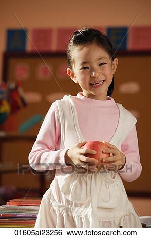 Stock Photograph - Student with apple in class. Fotosearch