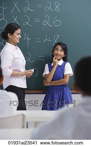 Stock Image - teacher and girl at chalkboard. Fotosearch