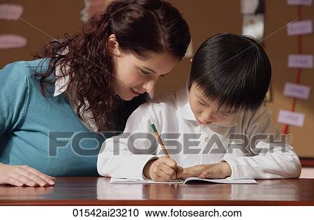 Stock Image - Teacher helping young student. Fotosearch