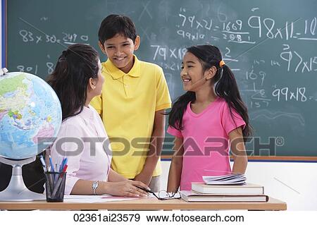 teacher speaking to two students, students smiling View Large Photo Image Stock Photo - teacher speaking to two students, students smiling. Fotosearch