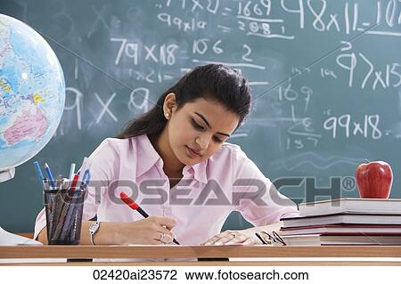 Stock Image - teacher working at desk. Fotosearch