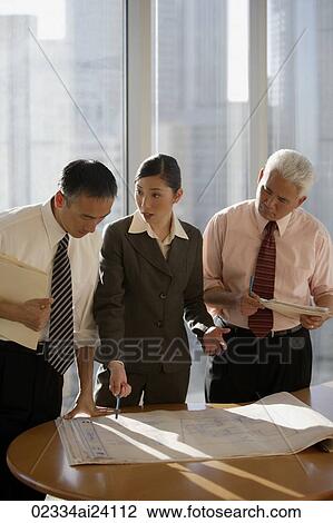 Stock Image - three colleagues discussing plans. Fotosearch