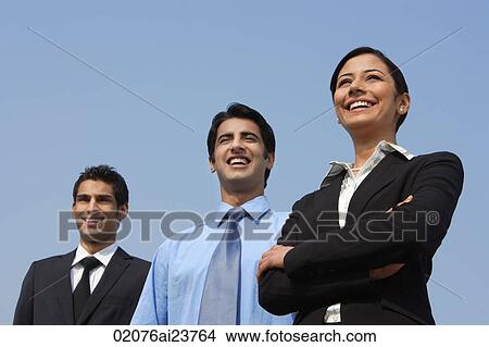 three colleagues standing, woman has arms folded View Large Photo Image Picture - three colleagues standing, woman has arms folded. Fotosearch