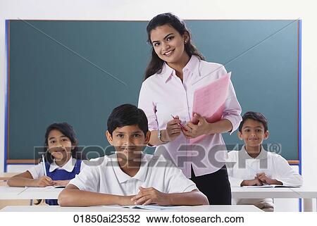 Stock Image - three students and teacher smile at camera. Fotosearch