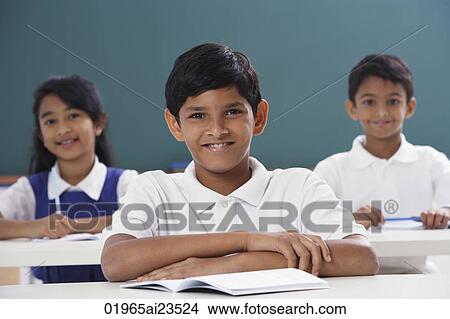 Picture - three students smiling at camera, boy in center. Fotosearch