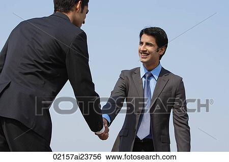 Stock Photograph - two businessmen shake hands (horizontal). Fotosearch