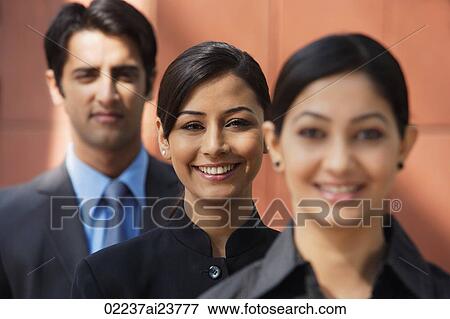 two businesswomen smiling at camera, one businessman (second woman in focus) View Large Photo Image Stock Photo - two businesswomen smiling at camera, one businessman (second woman in focus). Fotosearch
