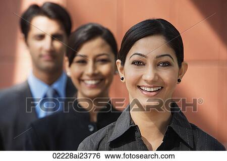 two businesswomen smiling at camera, one businessman (first woman in focus) View Large Photo Image Stock Photograph - two businesswomen smiling at camera, one businessman (first woman in focus). Fotosearch