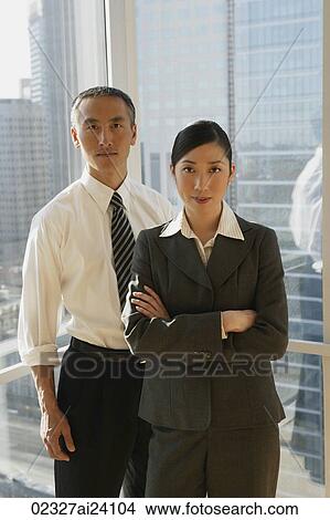 two colleagues standing in window View Large Photo Image Picture - two colleagues standing in window. Fotosearch