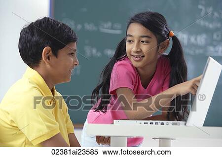 Stock Photography - two students at laptop, girl pointing to screen. Fotosearch