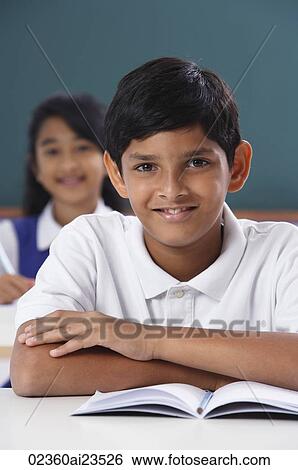 Stock Photograph - two students face camera, boy has arms crossed. Fotosearch