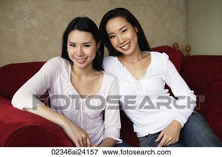 Stock Photo - two woman smiling on couch. Fotosearch