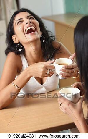 Stock Image - two young woman having coffee. Fotosearch