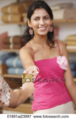 Stock Photo - woman handing gold card to cashier. Fotosearch