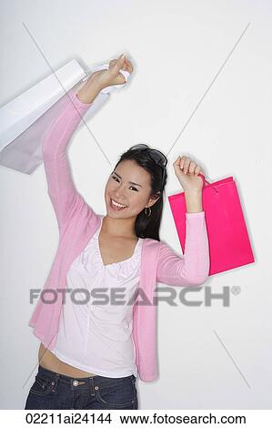 woman holding up shopping bags View Large Photo Image Picture - woman holding up shopping bags. Fotosearch