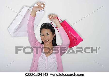 woman holding up shopping bags View Large Photo Image Stock Image - woman holding up shopping bags. Fotosearch