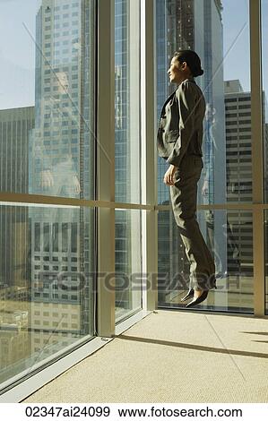 Stock Photo - woman jumping in corner of office. Fotosearch