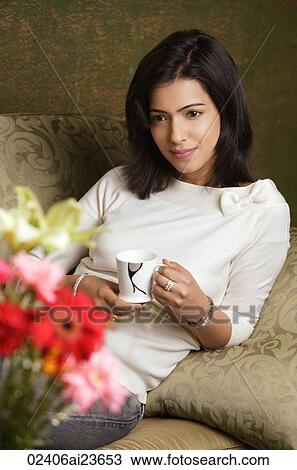 woman reclines on arm holding cup of tea View Large Photo Image Stock Image - woman reclines on arm holding cup of tea. Fotosearch