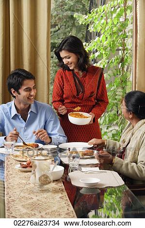 woman serves dinner to man and older woman (vertical) View Large Photo Image Picture - woman serves dinner to man and older woman (vertical). Fotosearch