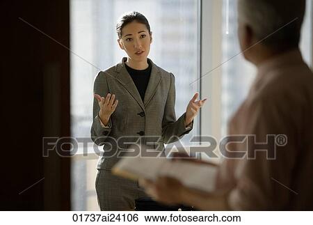 Stock Photograph - woman talking to colleague. Fotosearch