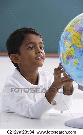young boy looks at globe, hands touching View Large Photo Image Picture - young boy looks at globe, hands touching. Fotosearch