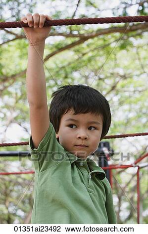 Young boy playing at the park View Large Photo Image Stock Image - Young boy playing at the park. Fotosearch