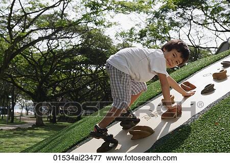 Young boy playing on rock-climbing wall View Large Photo Image Stock Photo - Young boy playing on rock-climbing wall. Fotosearch