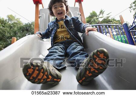 Young boy playing on slide View Large Photo Image Stock Photo - Young boy playing on slide. Fotosearch