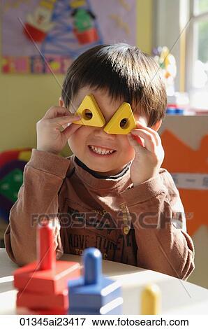 Young boy playing with stacking blocks, looking at camera View Large Photo Image Stock Photo - Young boy playing with stacking blocks, looking at camera. Fotosearch