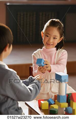 Stock Image - Young children playing with building blocks. Fotosearch