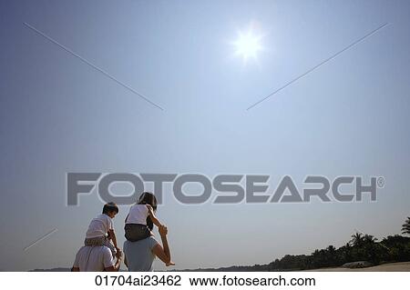 Young couple piggybacking children at the beach View Large Photo Image Stock Image - Young couple piggybacking children at the beach. Fotosearch