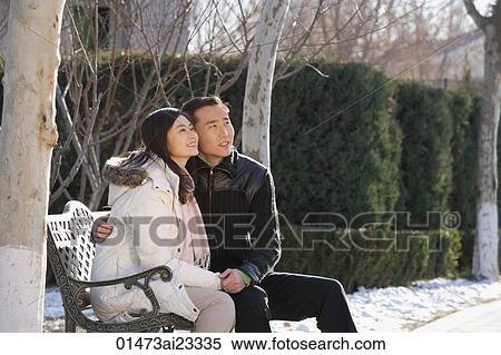 Young couple sitting on park bench View Large Photo Image Stock Photography - Young couple sitting on park bench. Fotosearch