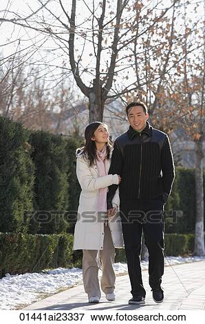 Young couple walking in park View Large Photo Image Stock Photo - Young couple walking in park. Fotosearch