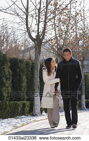 Young couple walking in park View Large Photo Image Stock Photograph - Young couple walking in park. Fotosearch