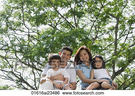 Young family at the park, looking at camera View Large Photo Image Stock Photograph - Young family at the park, looking at camera. Fotosearch