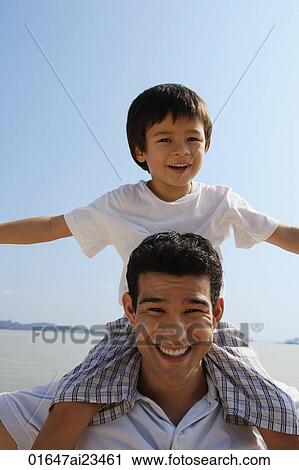 Young family sitting on park bench smiling at camera View Large Photo Image Stock Image - Young family sitting on park bench smiling at camera. Fotosearch