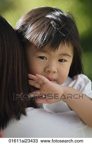 Stock Image - Young girl being carried, looking at camera. Fotosearch