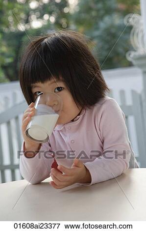 Young girl drinking glass of milk, looking at camera View Large Photo Image Stock Photo - Young girl drinking glass of milk, looking at camera. Fotosearch