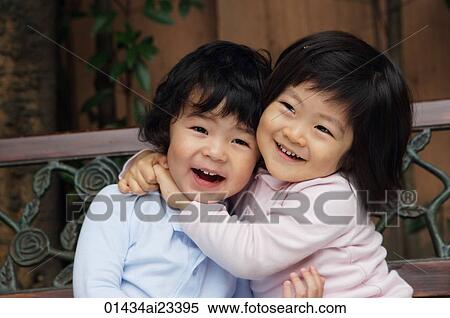 Young girl hugging young boy with happy smile View Large Photo Image Stock Photography - Young girl hugging young boy with happy smile. Fotosearch