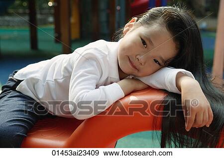 Stock Photo - Young girl in playground, looking at camera. Fotosearch