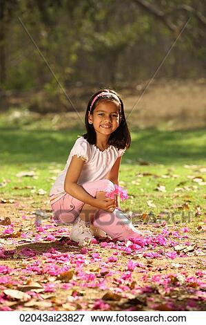 young girl kneeling in park View Large Photo Image Stock Photo - young girl kneeling in park. Fotosearch