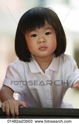Stock Image - Young girl looking at camera. Fotosearch